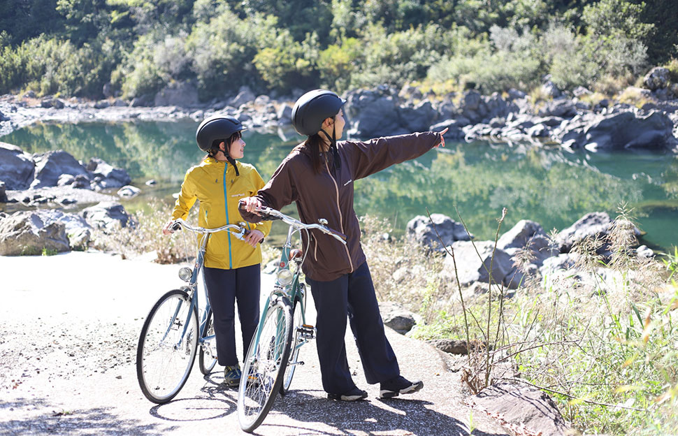 川辺で景色を楽しむサイクリスト